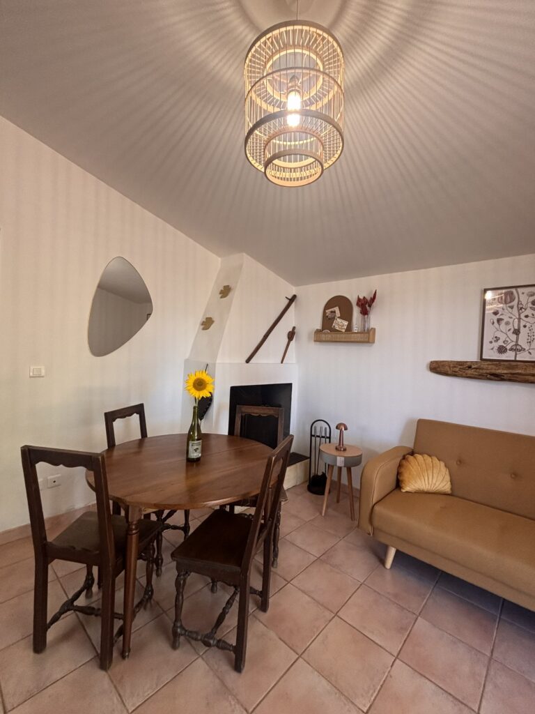 Salon salle à manger avec cheminée et bouteille de vin vase à tournesol, gîte à louer dordogne